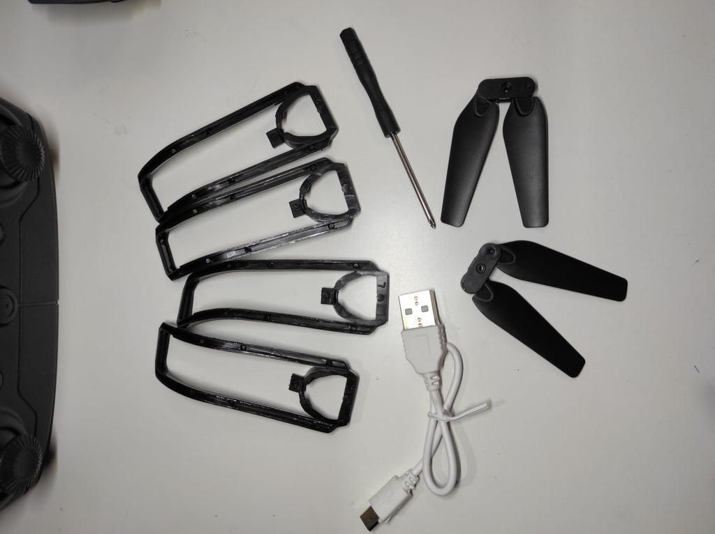 Accesorios para dron doble cámara 4K, incluyendo hélices, USB y herramienta de ajuste.
