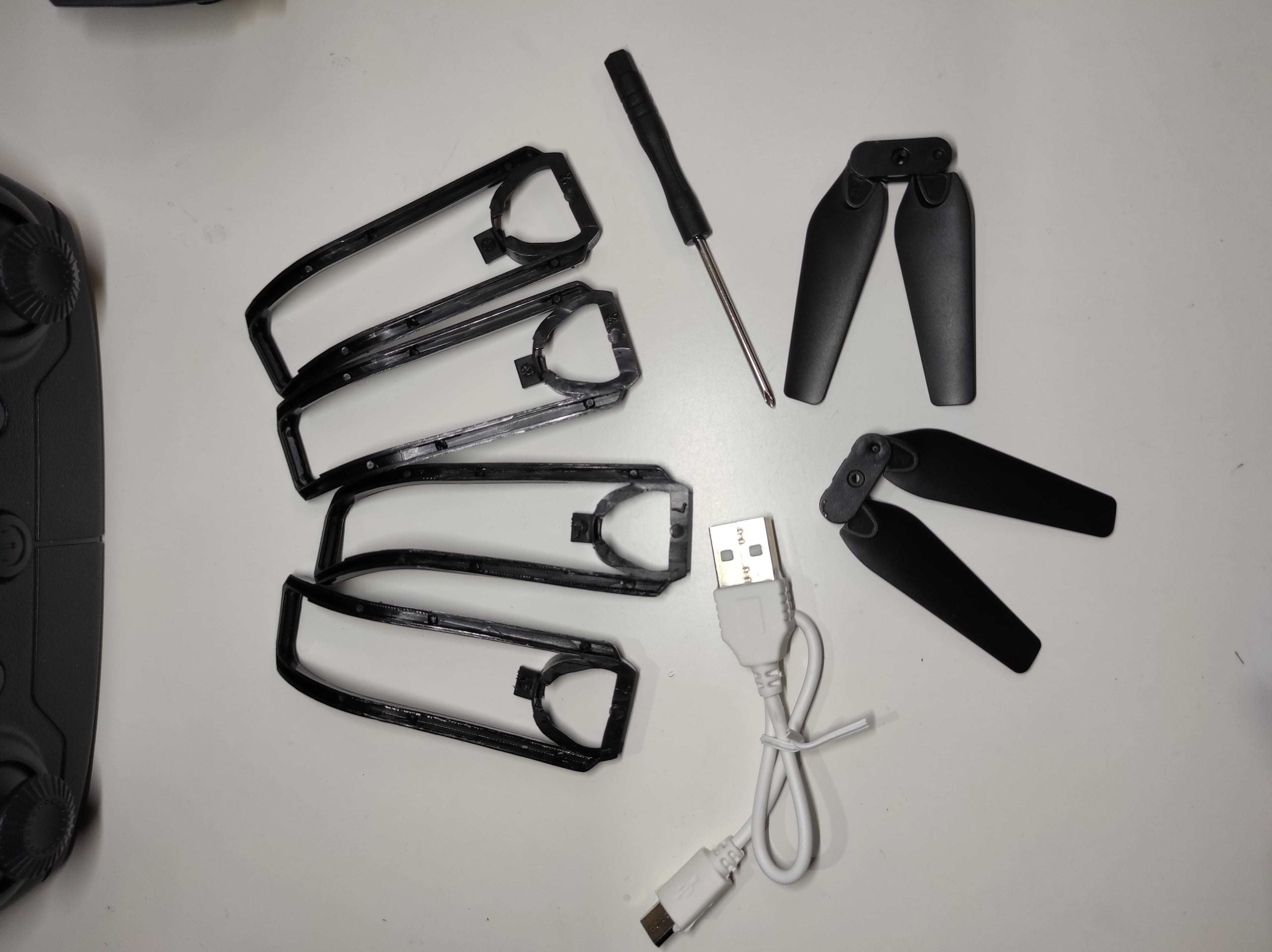 Accesorios para dron doble cámara 4K, incluyendo hélices, USB y herramienta de ajuste.